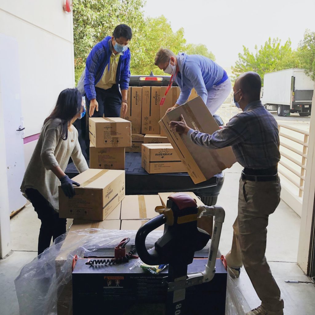 A group of volunteers loading boxes into a pickup truck.