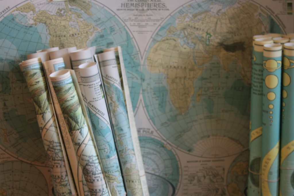 Rolls of maps in front of a map on a wall