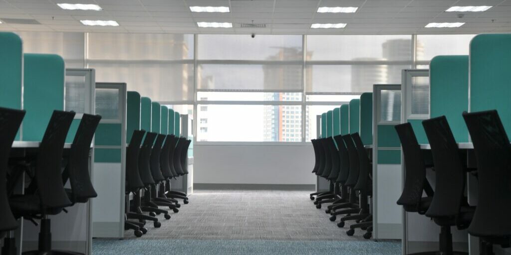 chairs and desks in cubicles at an office