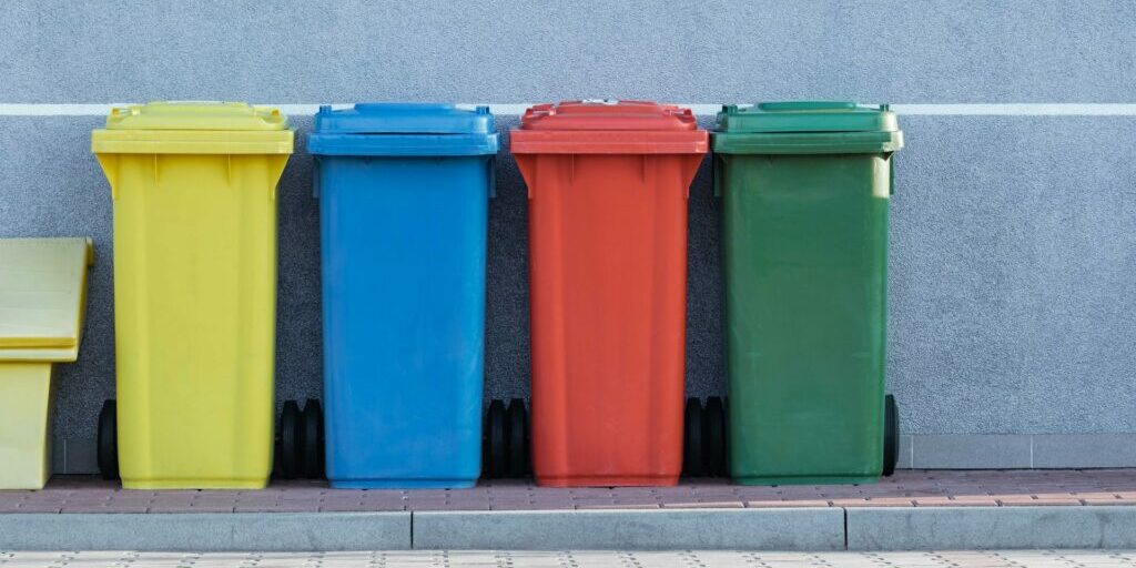 Multicolored recycling bins on a sidewalk